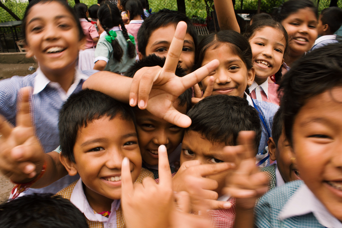 Grupo de niños felices en la escuela posando y saludando para la foto