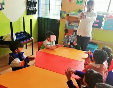 Niños aprendiendo la técnica de lavado de manos con la enfermera